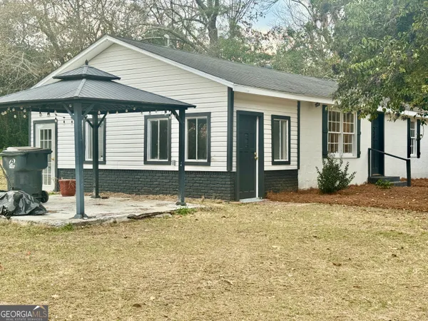 a front view of a house with yard and trees