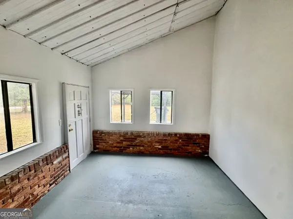 a spacious bedroom with a bed and a window