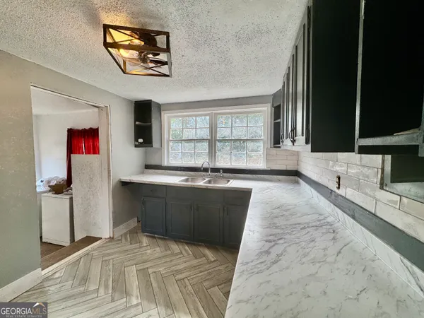 a kitchen with stainless steel appliances kitchen island granite countertop a refrigerator and a sink