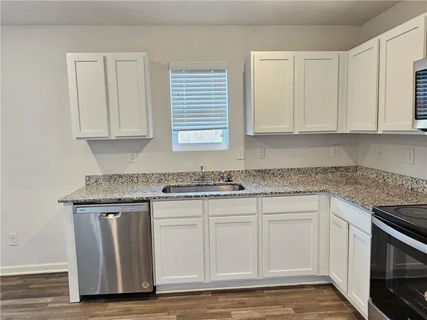a kitchen with granite countertop wooden cabinets and a sink