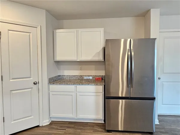 a white refrigerator freezer and a wooden floor