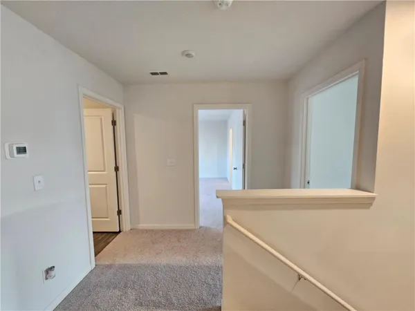 a view of a room with wooden floor and white walls