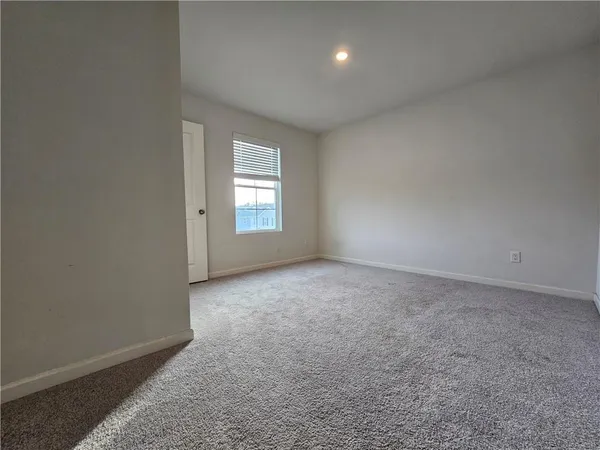 a view of a big room with windows and chandelier fan