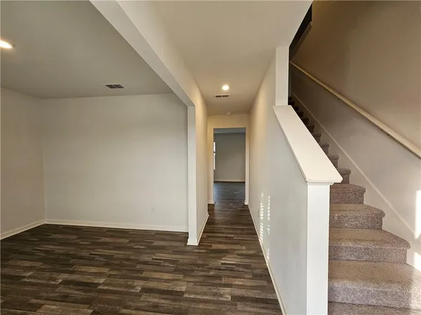a view of a hallway with wooden floor and staircase