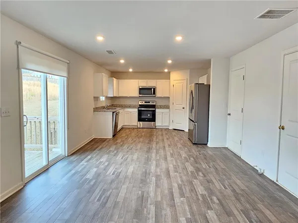 a open kitchen with a refrigerator and a stove top oven