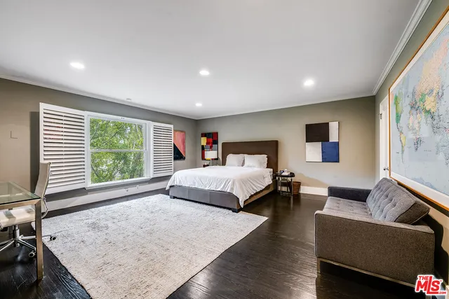 a bedroom with a bed and a large window