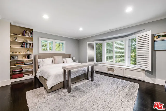 a bedroom with a bed and large windows