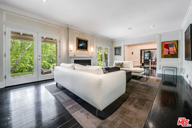 a kitchen with stainless steel appliances kitchen island granite countertop a stove a sink dishwasher a refrigerator and white cabinets with wooden floor