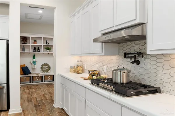 a kitchen with stainless steel appliances granite countertop a sink a stove and cabinets