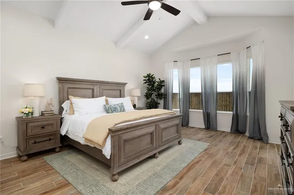 a spacious bedroom with a bed and a chandelier