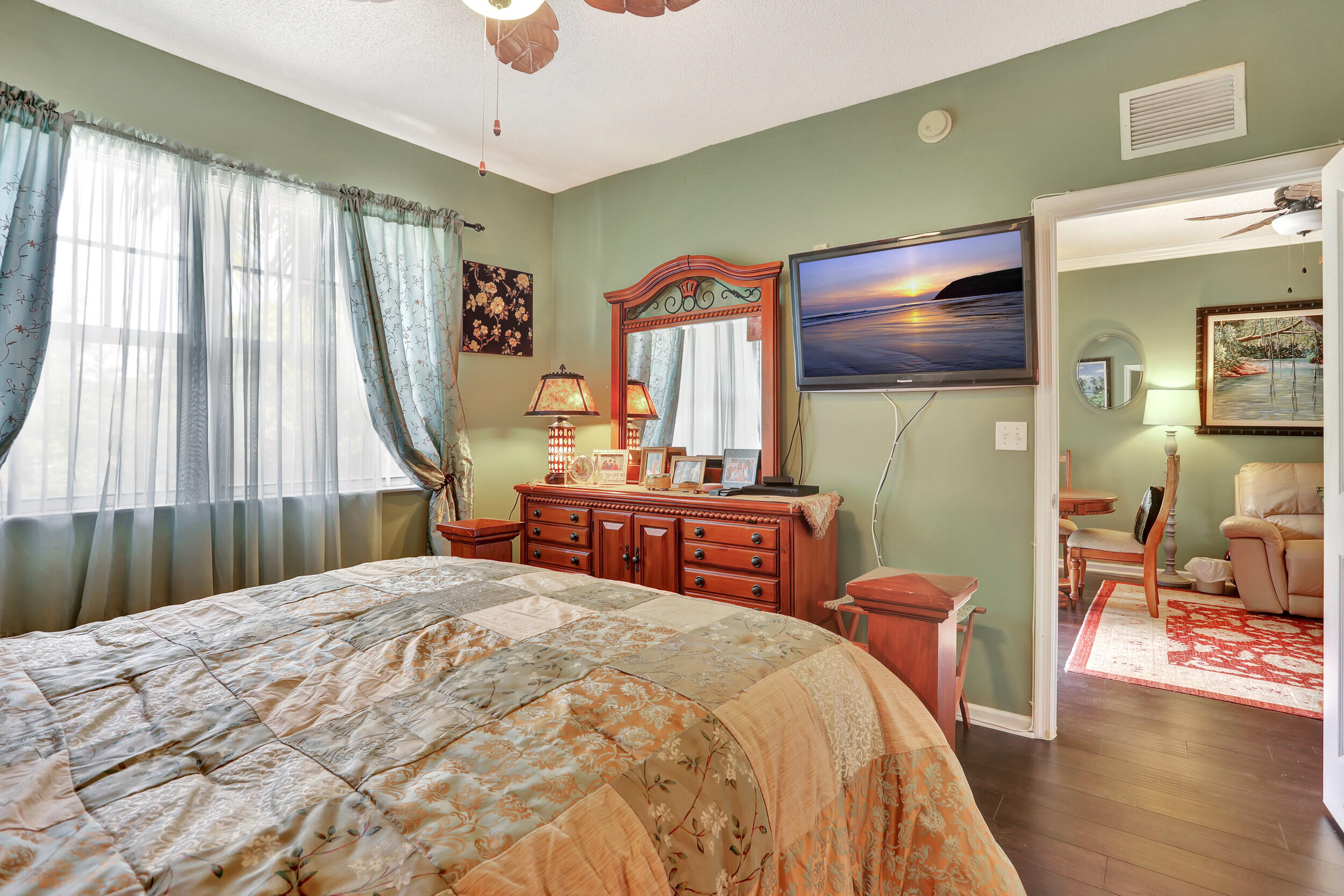 5800 West Sample Road, Unit 206 Coral Springs, FL 33067 - Photo 15 of 24 a bedroom with a bed and wooden floor