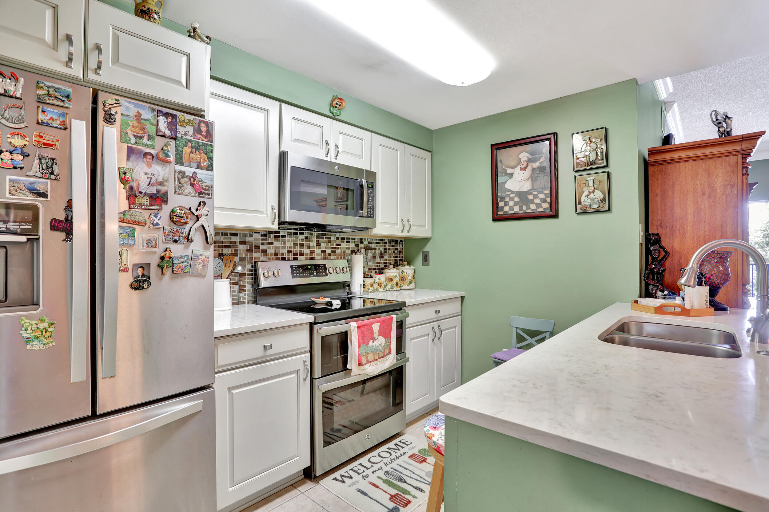 5800 West Sample Road, Unit 206 Coral Springs, FL 33067 - Photo 7 of 24 a kitchen with stainless steel appliances granite countertop a stove and a refrigerator