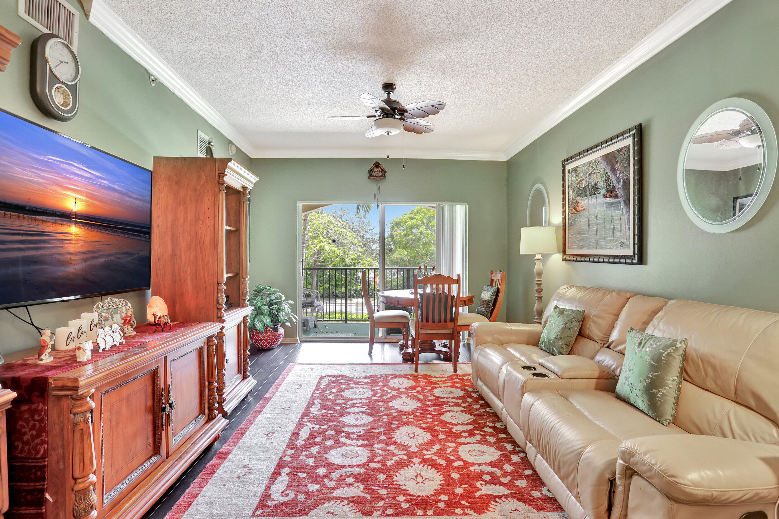 5800 West Sample Road, Unit 206 Coral Springs, FL 33067 - Photo 9 of 24 a living room with furniture a flat screen tv and a floor to ceiling window