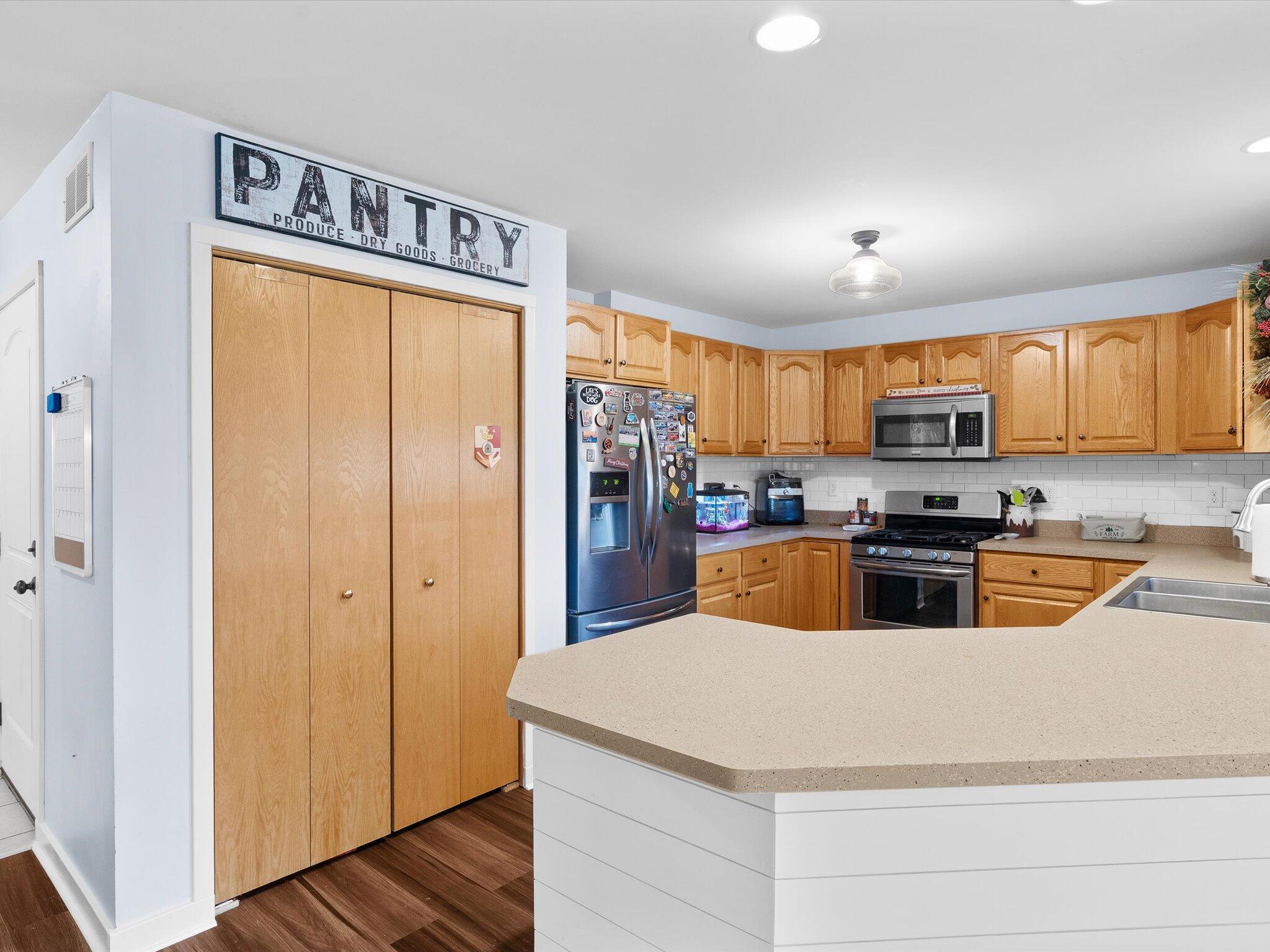 8407 Heron Lake Road St. John, IN 46373 - Photo 9 of 22 a kitchen with stainless steel appliances granite countertop a refrigerator a sink a stove a oven with a dining table and chairs