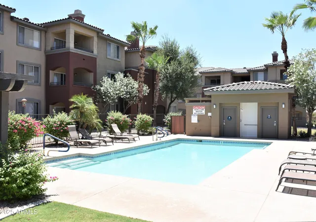 a swimming pool with outdoor seating yard and palm tree