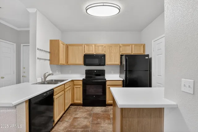 a kitchen with a sink a stove top oven and refrigerator