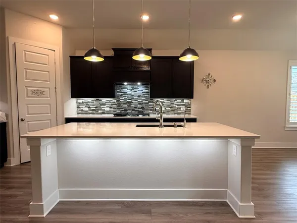 a view of kitchen with granite countertop window and wooden floor