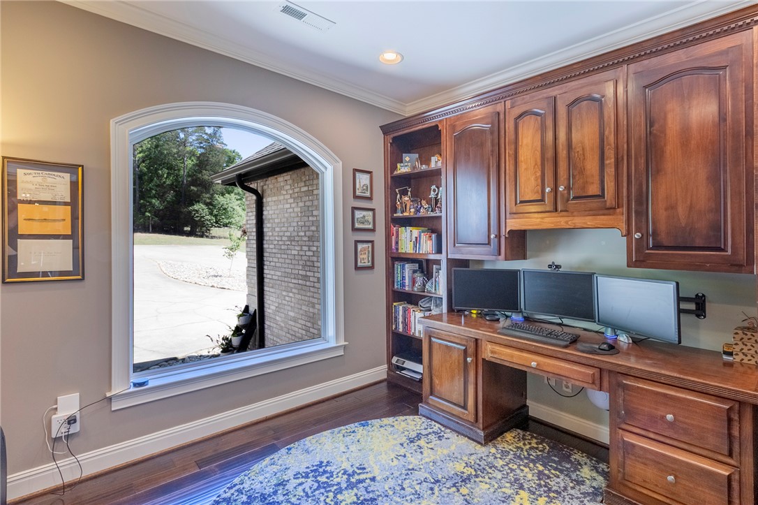 4420 Denver Cove Road Anderson, SC 29625 - Photo 23 of 50 This dedicated workspace offers rich wood cabinetry and ample natural light through an arched window.