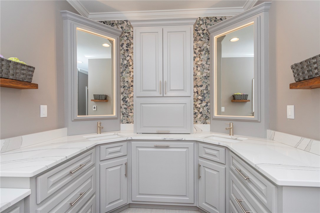 4420 Denver Cove Road Anderson, SC 29625 - Photo 28 of 50 This primary bathroom offers a double vanity with ample storage, sleek countertops, and modern mirrors.
