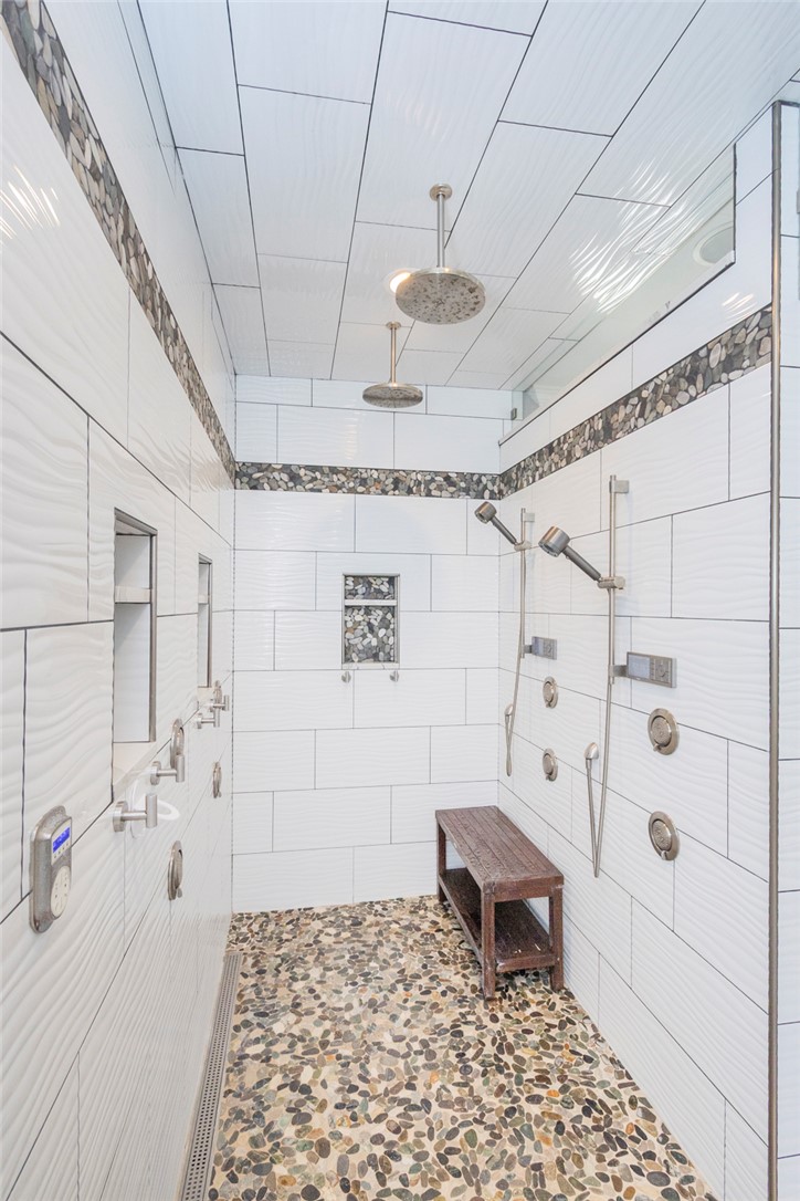 4420 Denver Cove Road Anderson, SC 29625 - Photo 30 of 50 This spacious shower features sleek tile, a built-in bench, and a unique pebble floor.