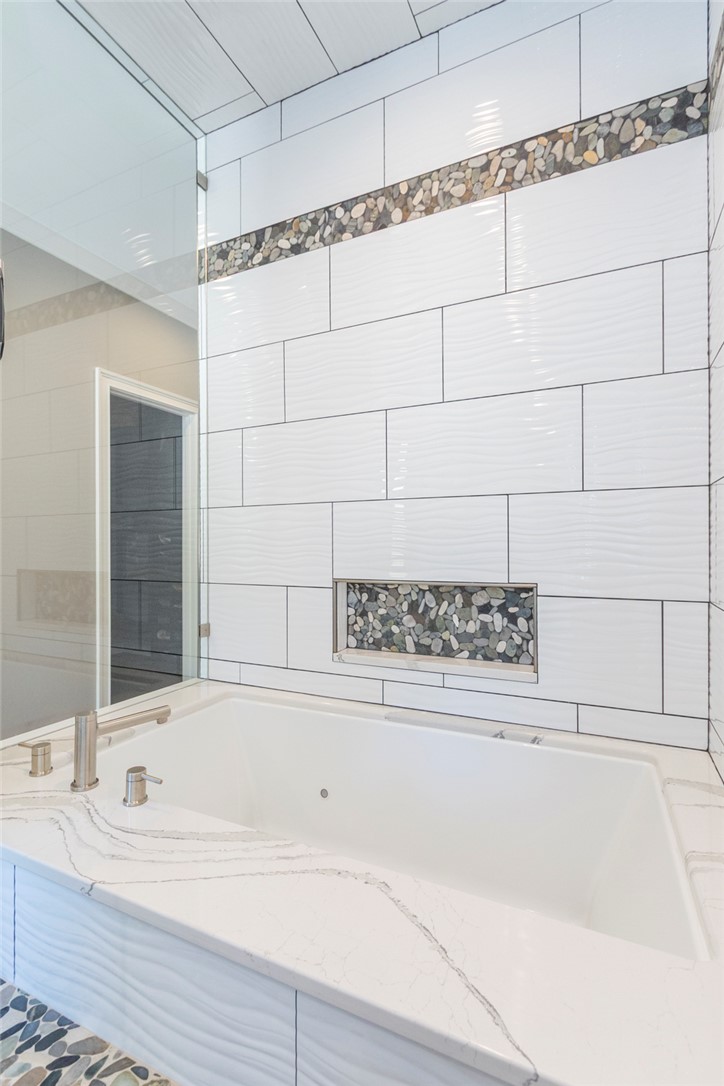 4420 Denver Cove Road Anderson, SC 29625 - Photo 31 of 50 This primary bathroom features a spacious soaking tub, complemented by elegant tilework and modern fixtures.