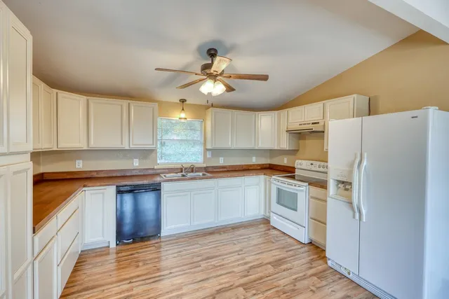 a kitchen with granite countertop a refrigerator and a sink