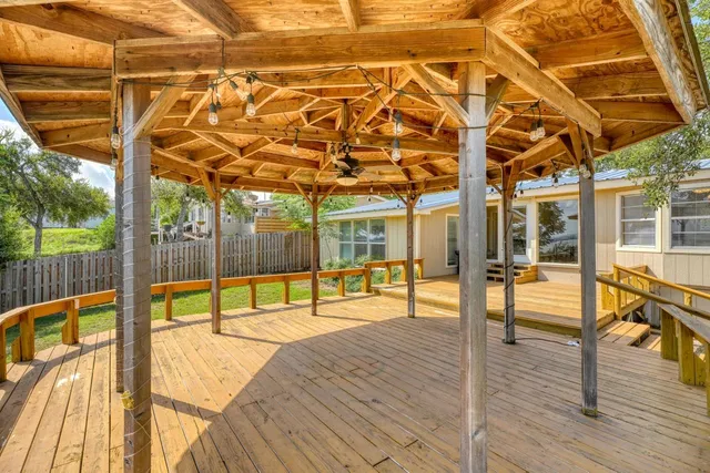 a view of a swimming pool with wooden deck and dining room