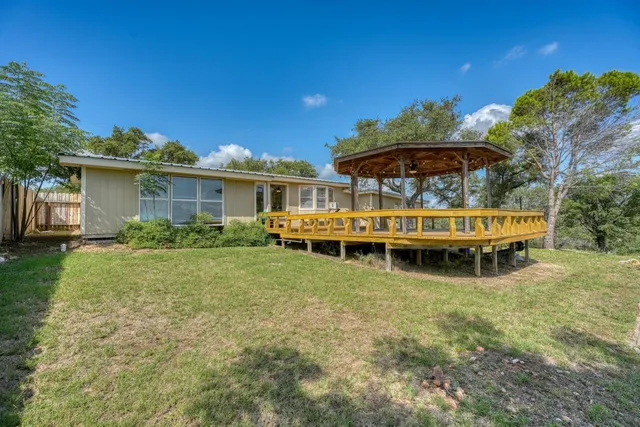 a view of a house with a garden and sitting area