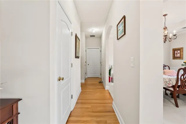 a view of a hallway with wooden floor and a potted plant