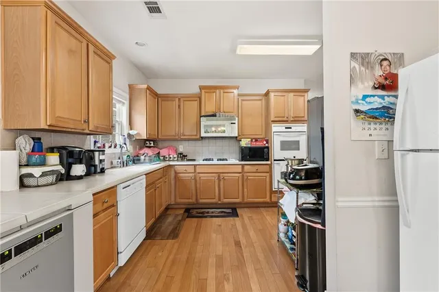 a kitchen with a refrigerator a sink and white cabinets