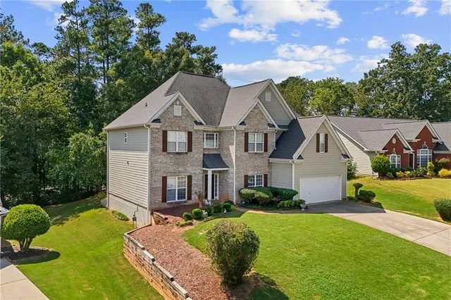 a front view of a house with yard and green space