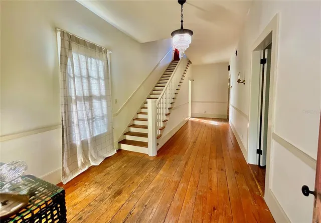 a view of entryway and hall with wooden floor