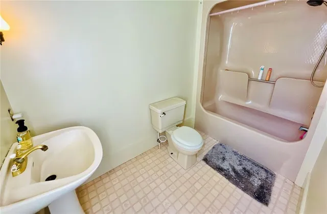 a bathroom with a sink and mirror with bathtub