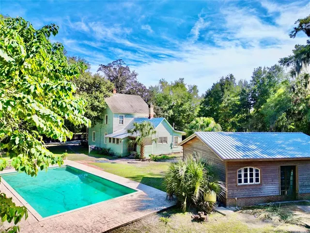 a view of a swimming pool with a yard and plants
