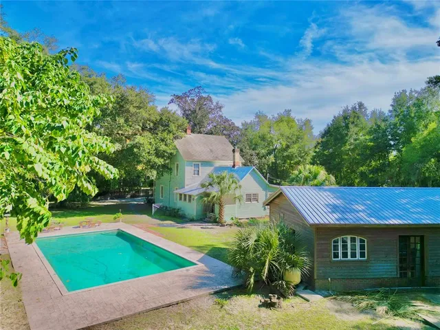 a view of a house with a yard and wooden fence
