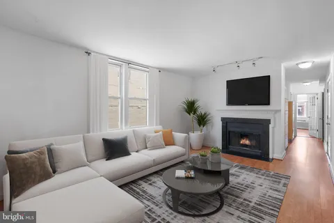 a living room with furniture a fireplace and a flat screen tv