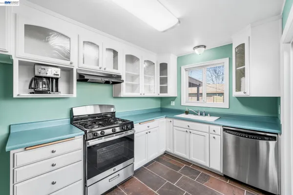 a kitchen with stainless steel appliances granite countertop a stove and cabinets