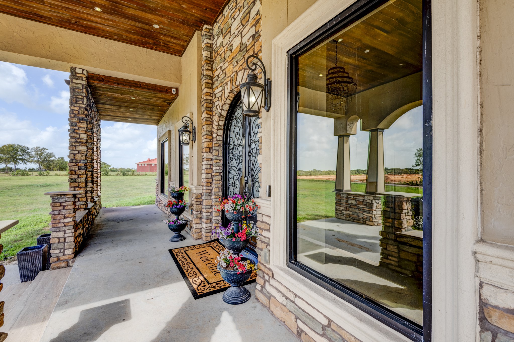 7348 Love Road Fulshear, TX 77441 - Photo 44 of 48 Entryway with a welcoming atmosphere, featuring ornate wrought iron doors and lush surrounding greenery.
