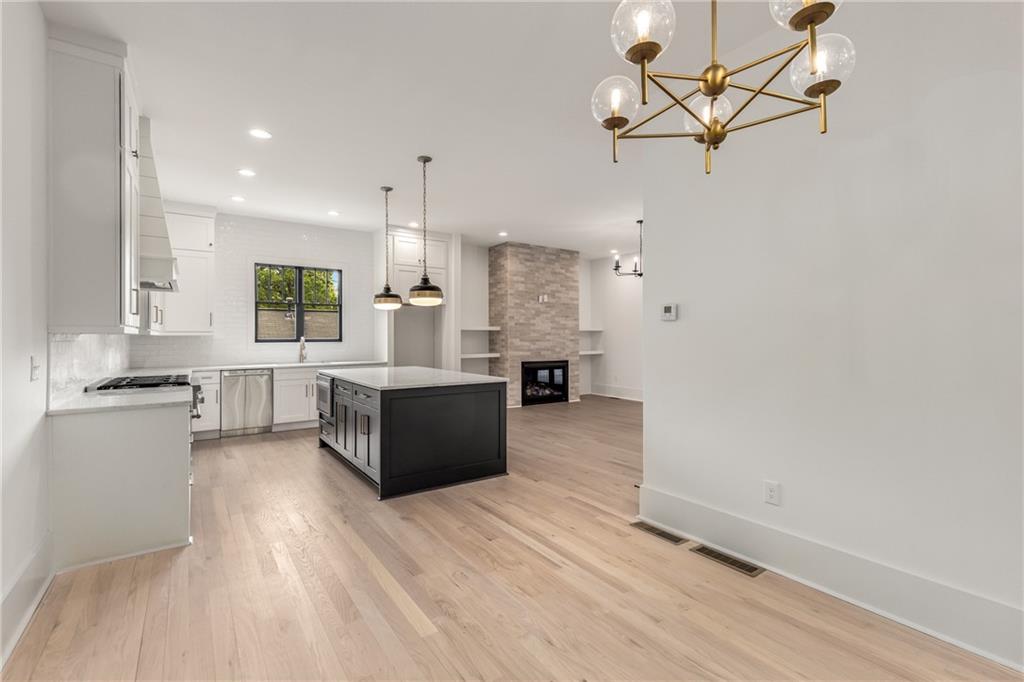 628 Robinson Avenue Southeast, Unit B Atlanta, GA 30312 - Photo 19 of 77 a large kitchen with stainless steel appliances a large counter top a stove and a refrigerator