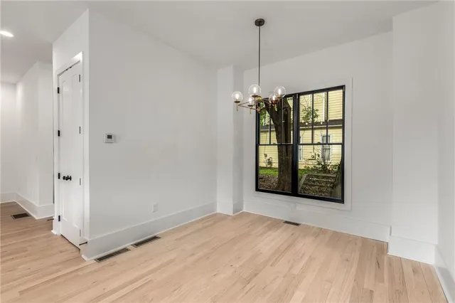 a view of hallway with walk in closet and wooden floor