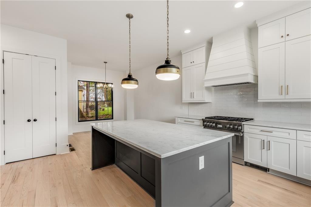 628 Robinson Avenue Southeast, Unit B Atlanta, GA 30312 - Photo 6 of 77 a kitchen with kitchen island a stove a sink a center island and wooden floor