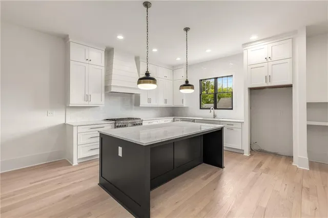 a kitchen with granite countertop a sink stove and refrigerator