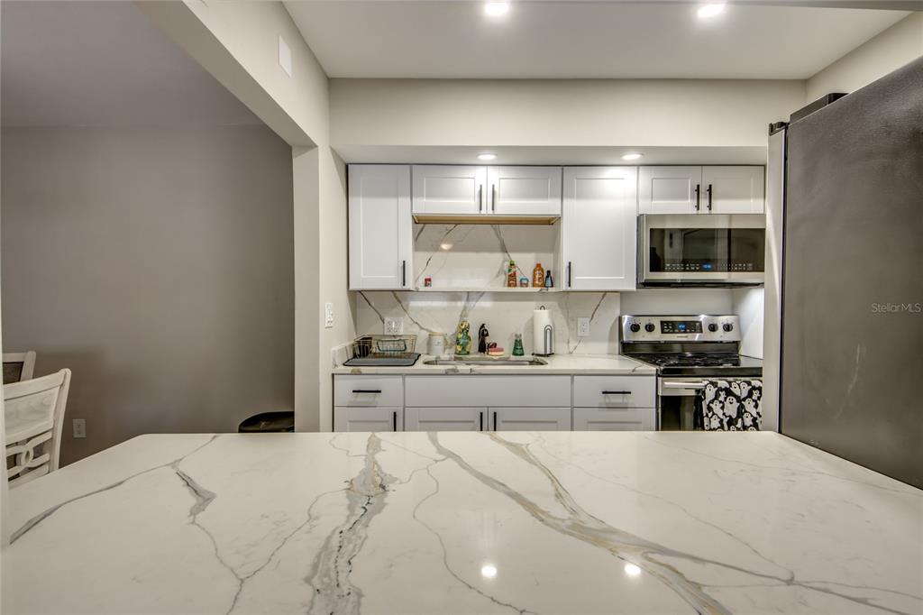 2544 First Street, Unit 107 Fort Myers, FL 33901 - Photo 17 of 35 a kitchen with a stove top oven and cabinets