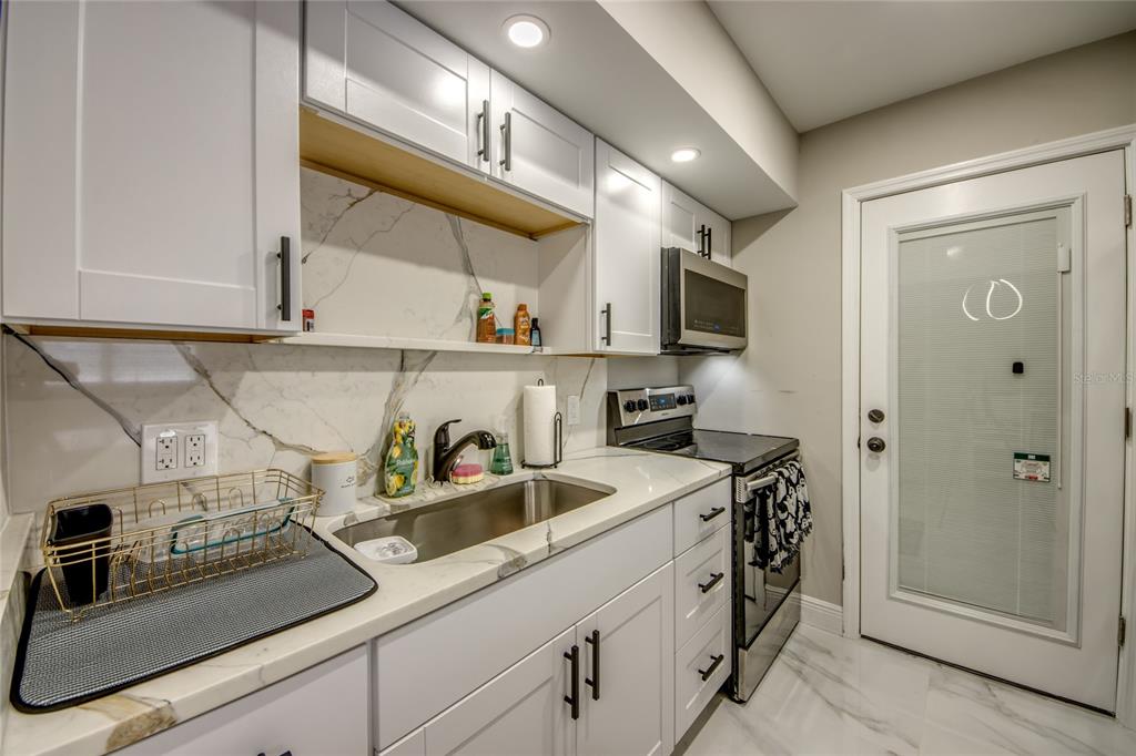 2544 First Street, Unit 107 Fort Myers, FL 33901 - Photo 20 of 35 a kitchen with stainless steel appliances granite countertop a sink stove and cabinets