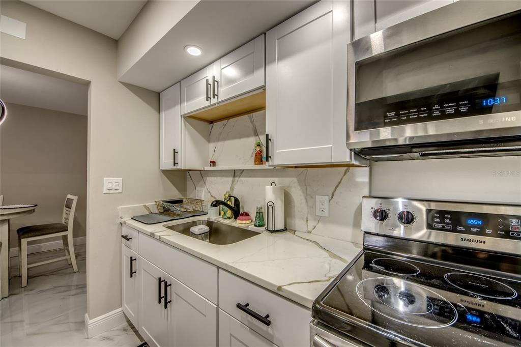 2544 First Street, Unit 107 Fort Myers, FL 33901 - Photo 22 of 35 a kitchen with a stove and a microwave