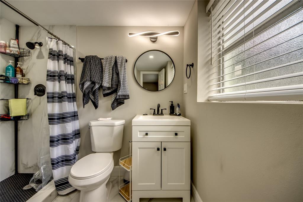 2544 First Street, Unit 107 Fort Myers, FL 33901 - Photo 27 of 35 a bathroom with a toilet sink and mirror