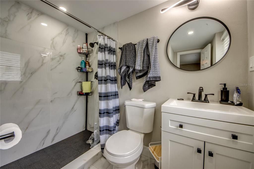 2544 First Street, Unit 107 Fort Myers, FL 33901 - Photo 28 of 35 a bathroom with a toilet sink and mirror