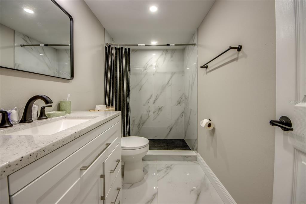 2544 First Street, Unit 107 Fort Myers, FL 33901 - Photo 30 of 35 a bathroom with a sink a toilet and shower