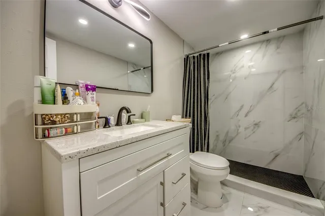 a bathroom with a sink toilet vanity and shower