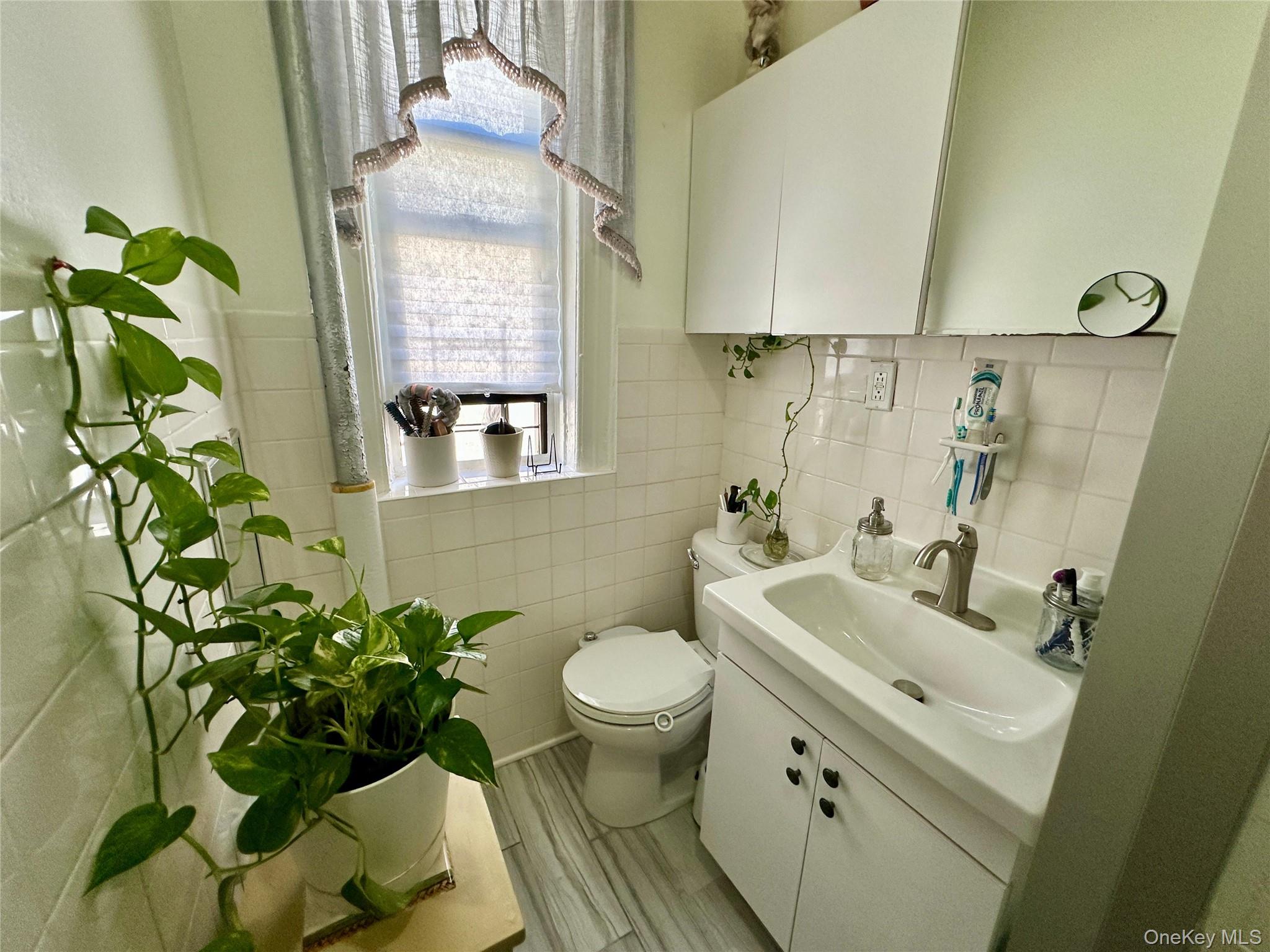 543 West 160th Street, Unit 5D Manhattan, NY 10032 - Photo 9 of 13 a bathroom with a toilet sink and mirror